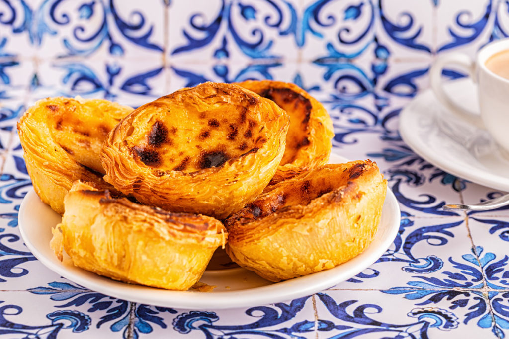 Ein Teller Pastéis de Nata auf Azulejo-Kacheln, Belém
