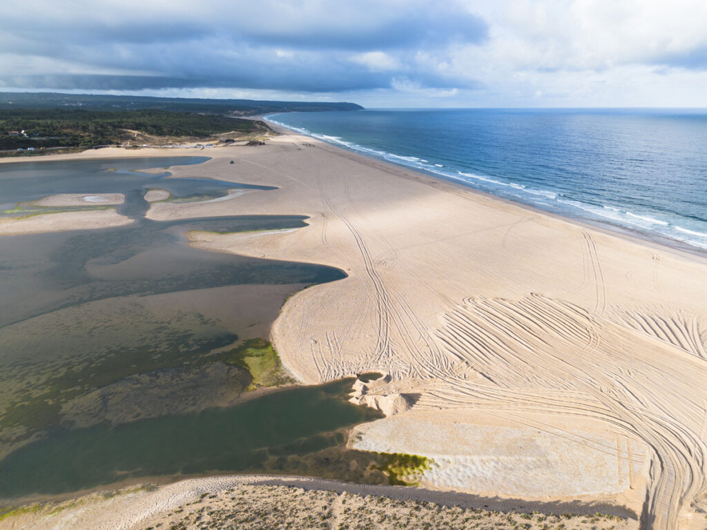 Aerial view of the Lagoa de Albufeira sandbar, separating the calm lagoon from the open Atlantic