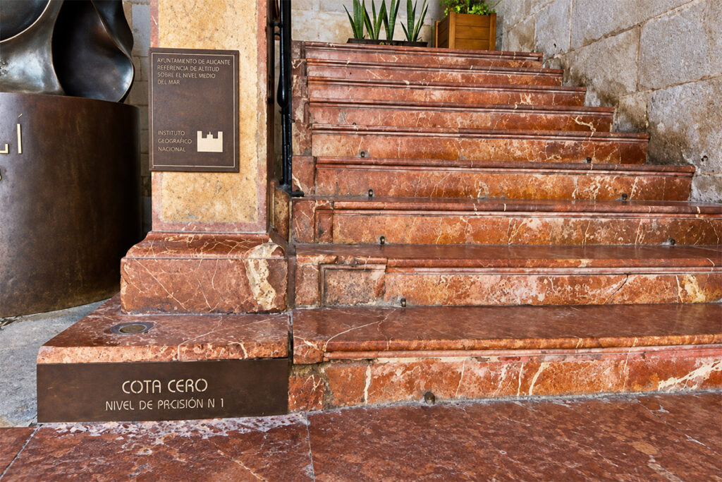 La marca de bronce de la Cota Cero en la escalinata del ayuntamiento, el punto de referencia oficial del nivel del mar en España