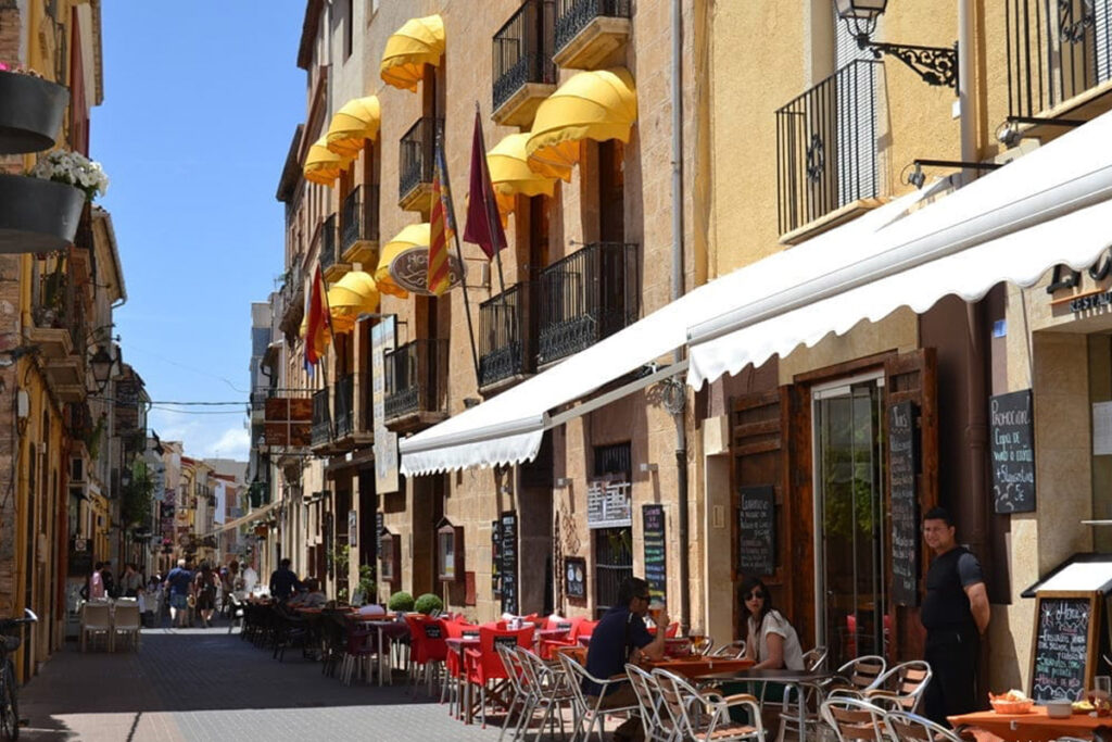 Cafés und Restaurants unter gelben Markisen in der Calle Loreto, Dénia