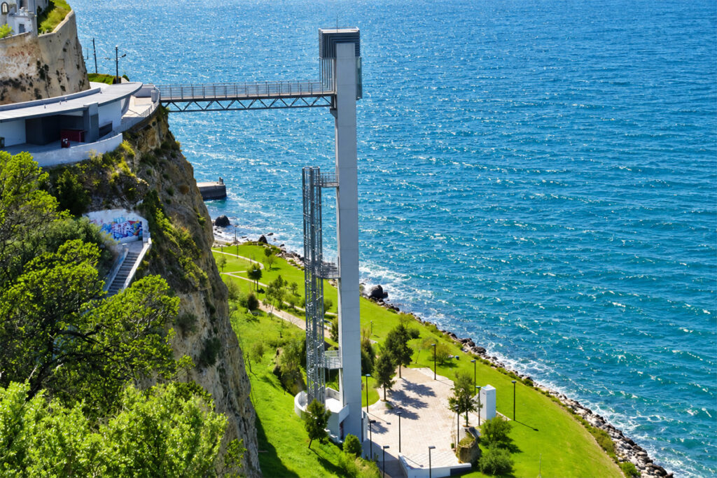 The Elevador da Boca do Vento tower dropping from the cliff to the riverside garden