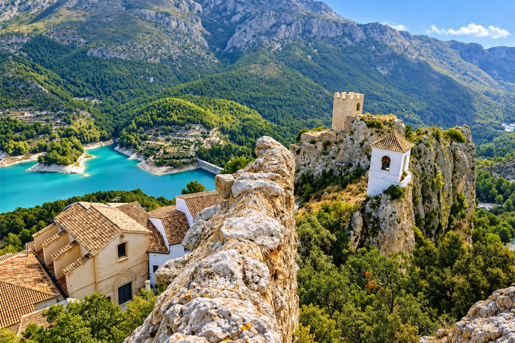 The castle and bell tower of Guadalest perched above the turquoise reservoir