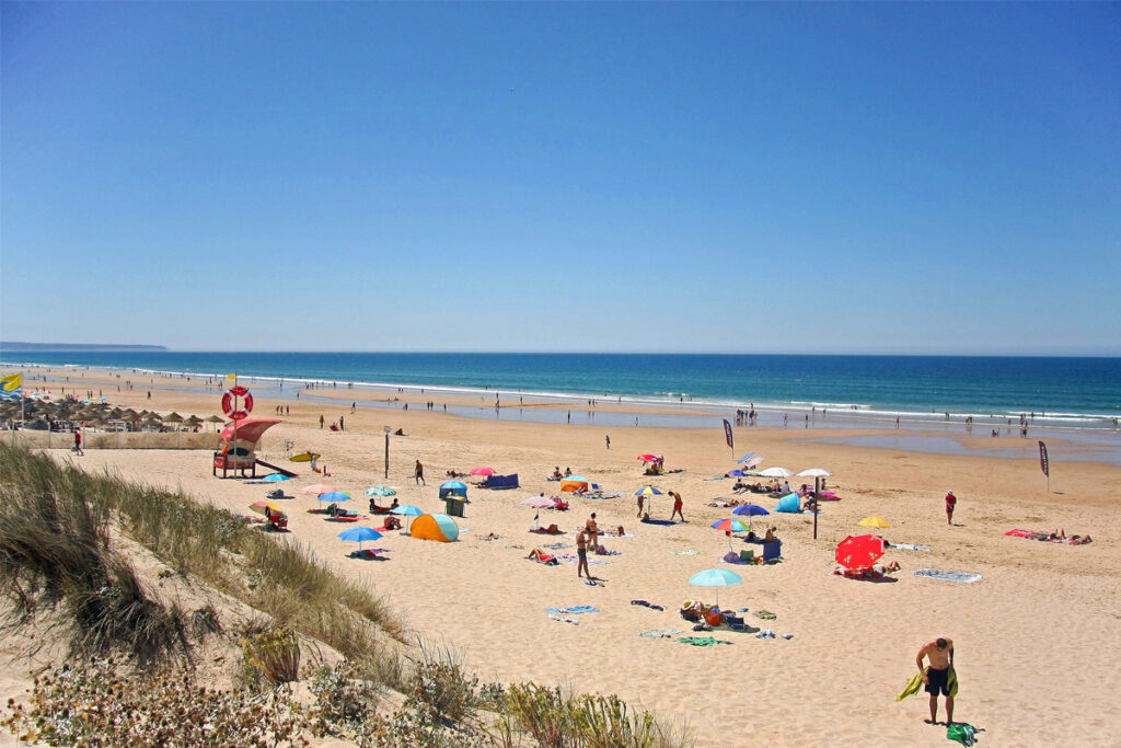 Praia da Sereia seen from the dunes, with the lifeguard tower and beach umbrellas