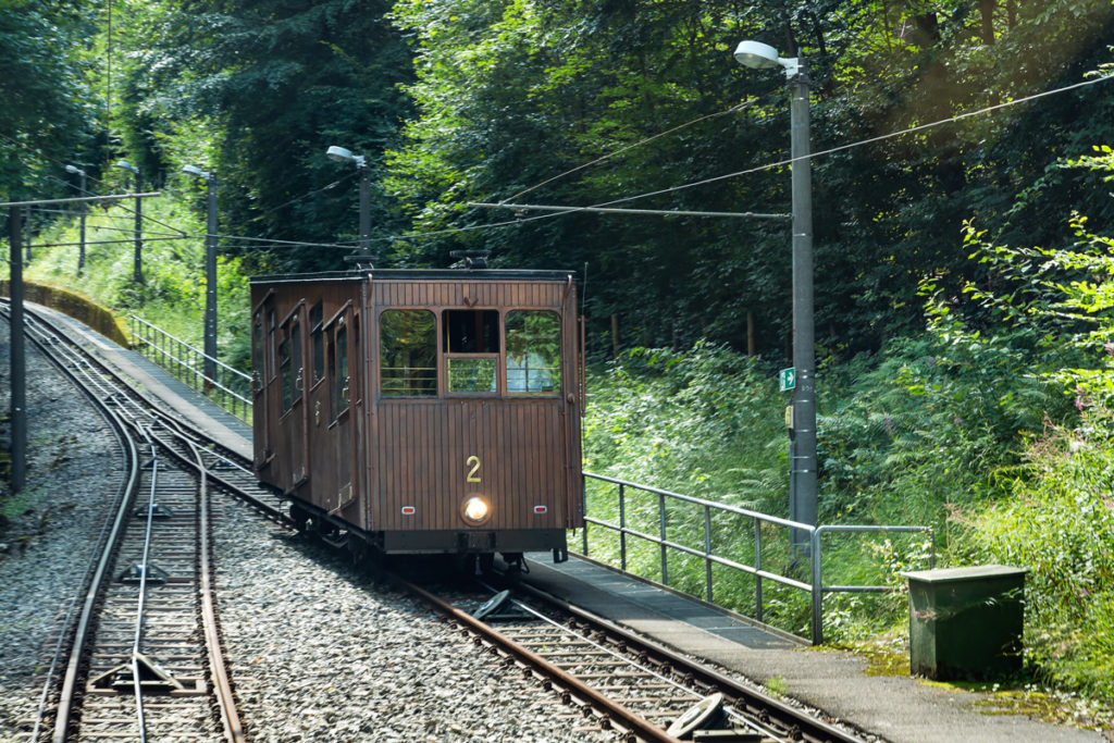 A wooden car of the 1929 Standseilbahn on the wooded climb to the Waldfriedhof