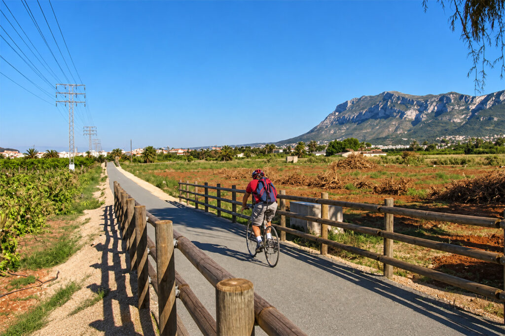 A cyclist on the Vía Verde de Dénia, with the Montgó rising behind