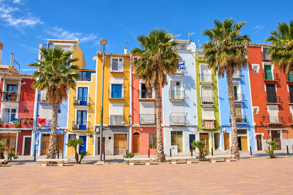 Palm trees in front of the painted houses on Villajoyosa's seafront